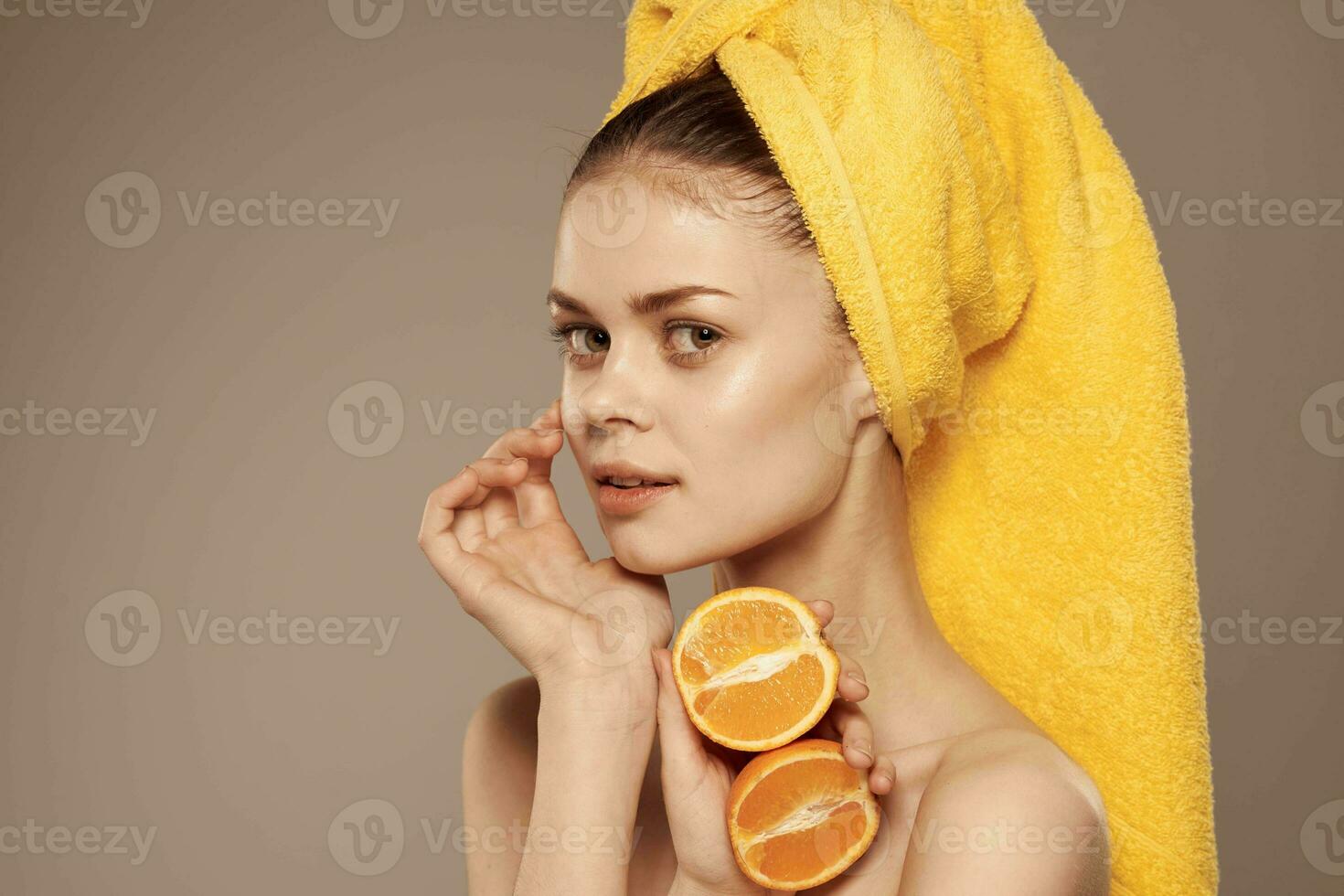 attraktiv kvinna med bar axlar med apelsiner i händer beskurna se beige bakgrund foto