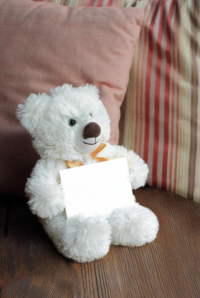 vit nallebjörn som håller ett tomt notekort foto