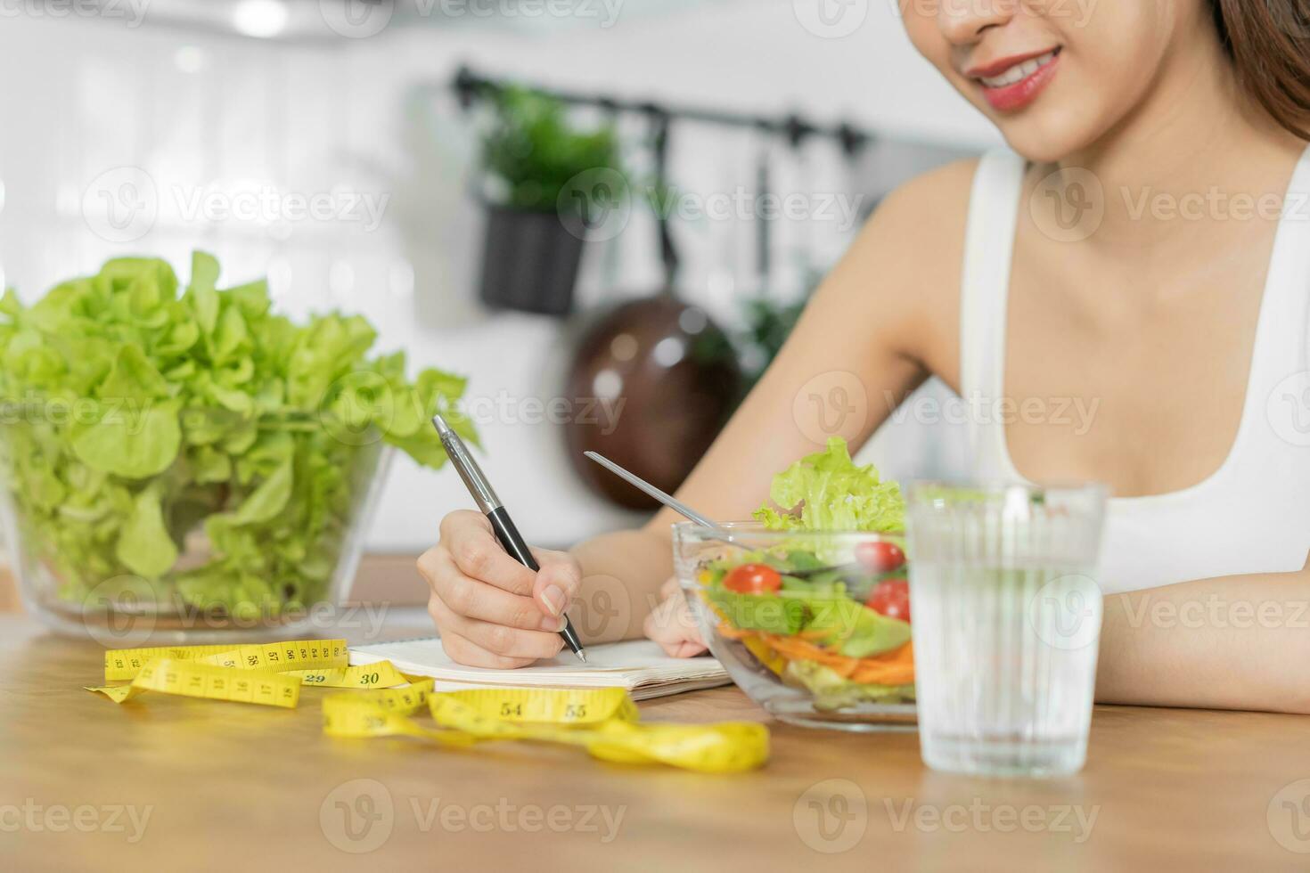 diet, bantning asiatisk ung kvinna arbetssätt, skriva diet planen rätt näring, grönsaker sallad är mat för Bra hälsa inte välja äta skräp mat. dietist kvinna, vikt förlust person. foto