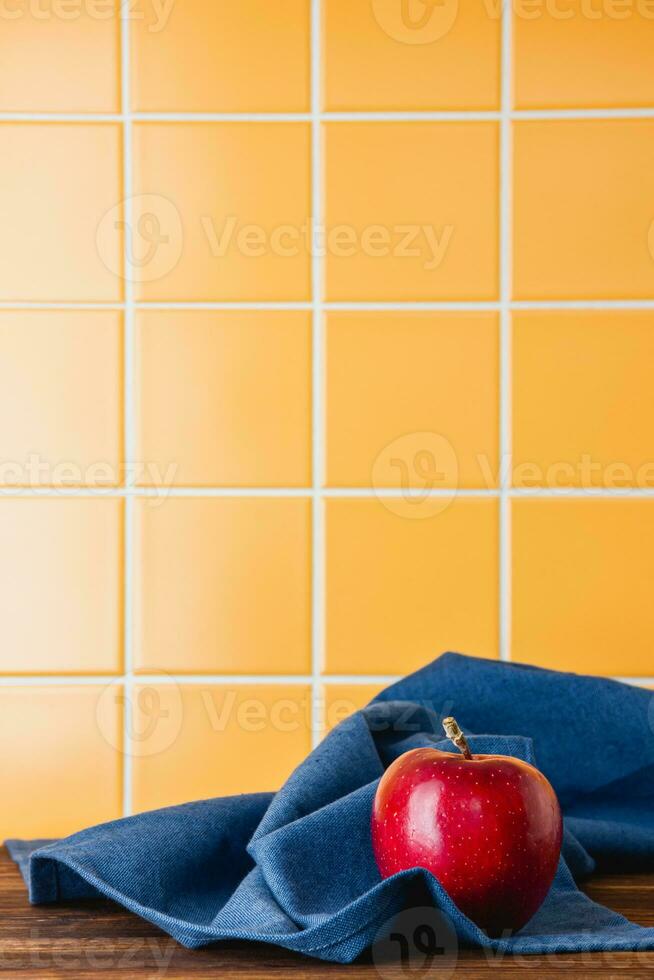 röd äpple på en blå handduk på en trä- tabell foto
