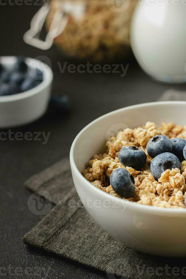 granola med blåbär i skål på mörk servett. foto