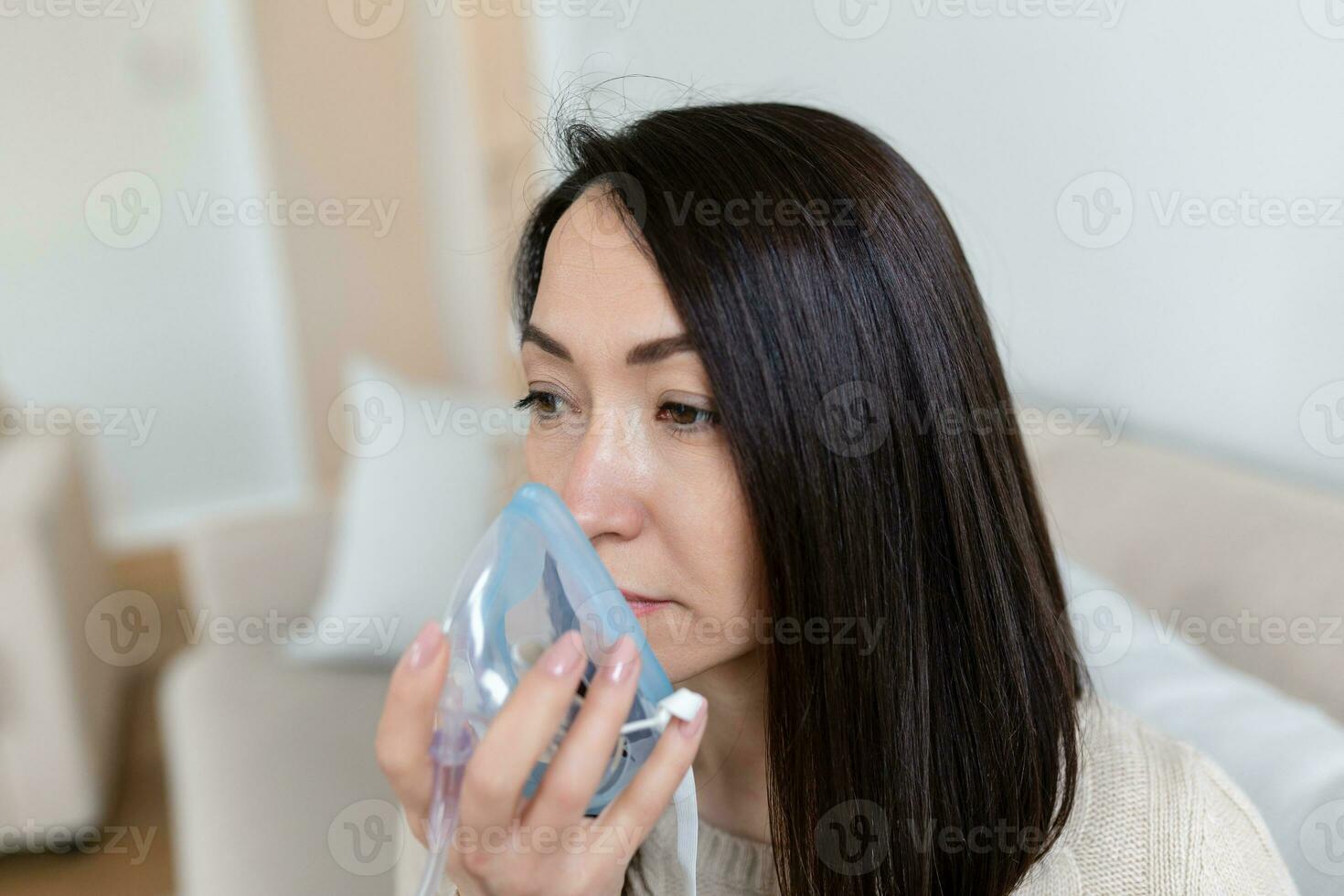 sjuk asiatisk kvinna framställning inandning, medicin är de bäst medicin. sjuk kvinna bär ett syre mask och genomgå behandling för covid19. kvinna med ett inhalator foto