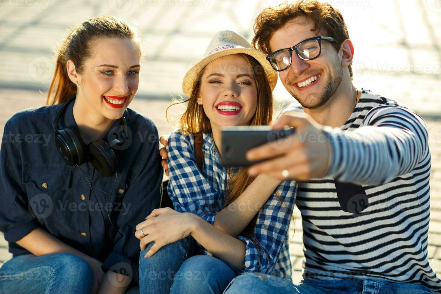 leende vänner framställning selfie utomhus foto