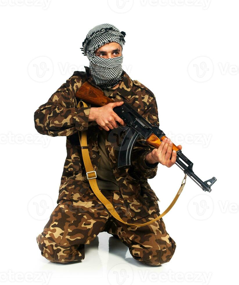 arab nationalitet i kamouflage kostym och keffiyeh med automatisk pistol på vit bakgrund foto
