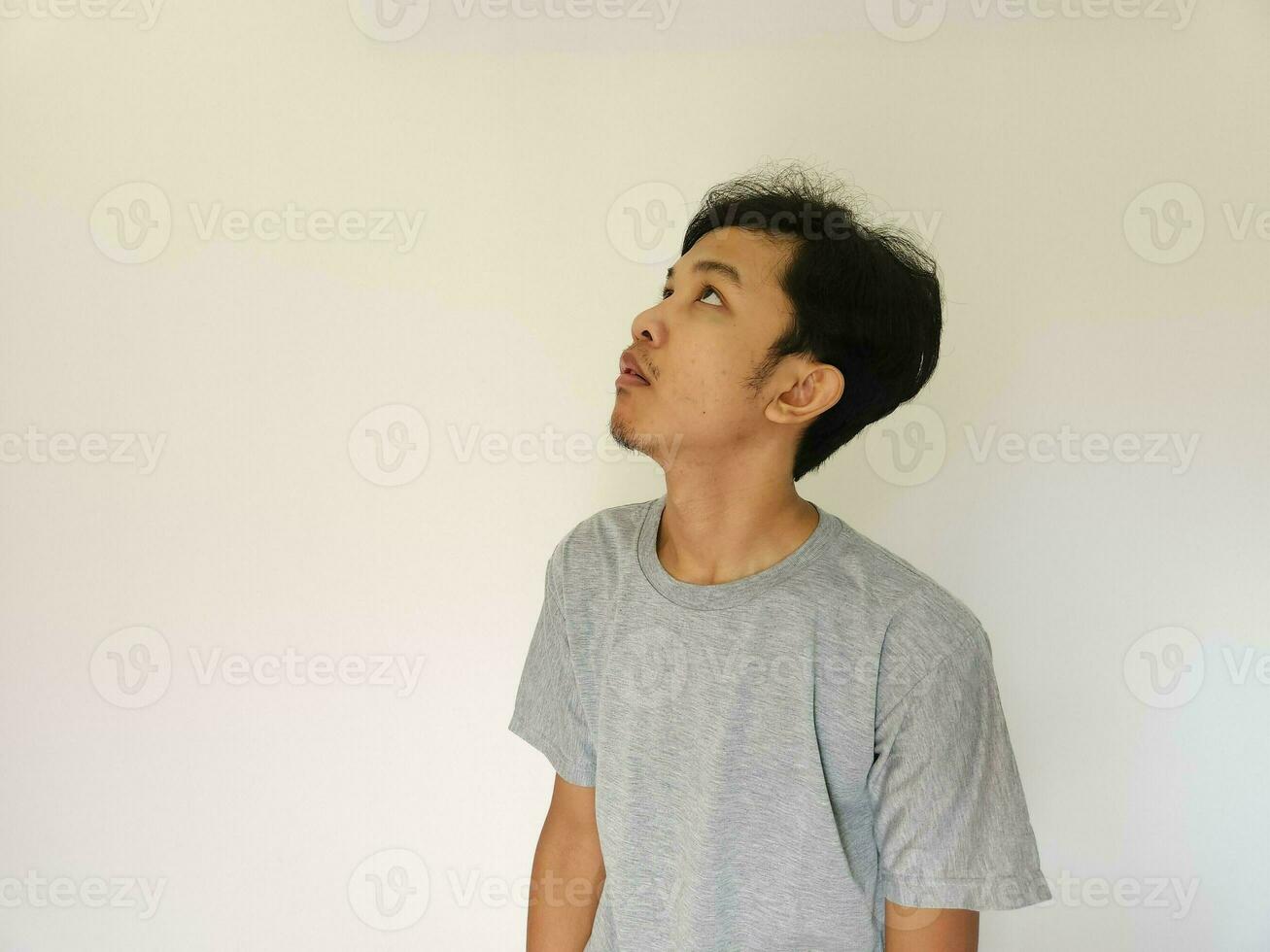 asiatisk man känner uttråkad och vänd upp med isolerat bakgrund foto