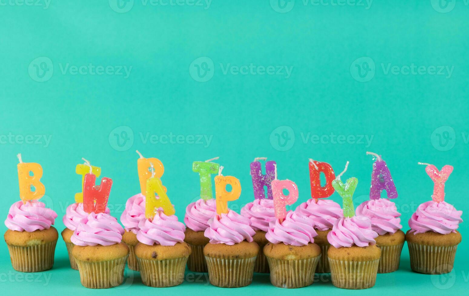 rosa kopp kaka med Lycklig födelsedag ljus på grön bakgrund, kopia Plats och årgång tona foto