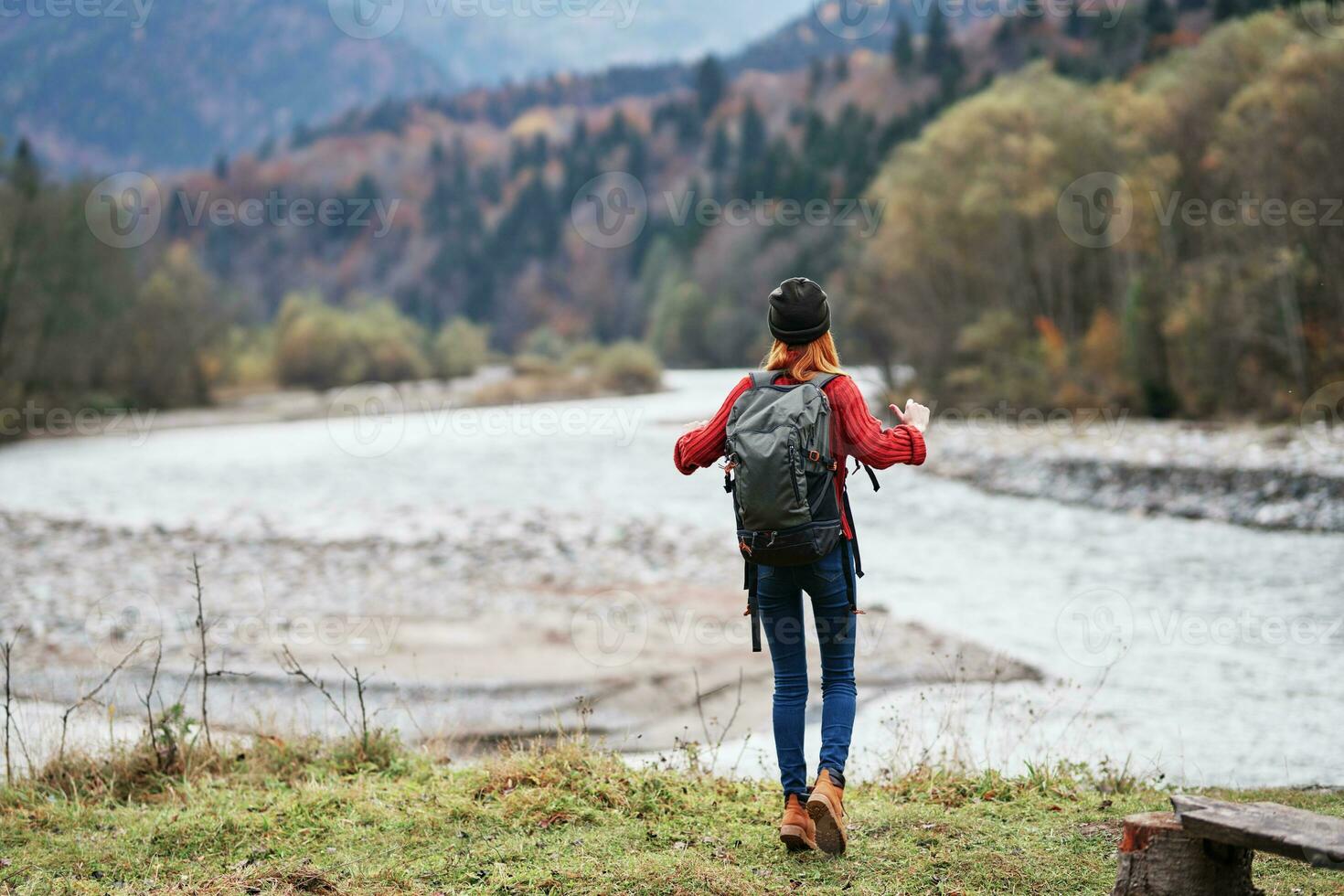 kvinna på de flod Bank i de skog och bergen i de bakgrund landskap turism resa foto