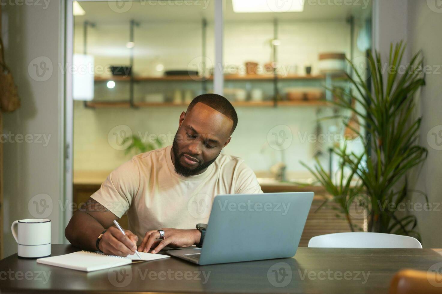 Lycklig afrikansk amerikan man bär tillfällig kläder arbetssätt i hans Hem foto