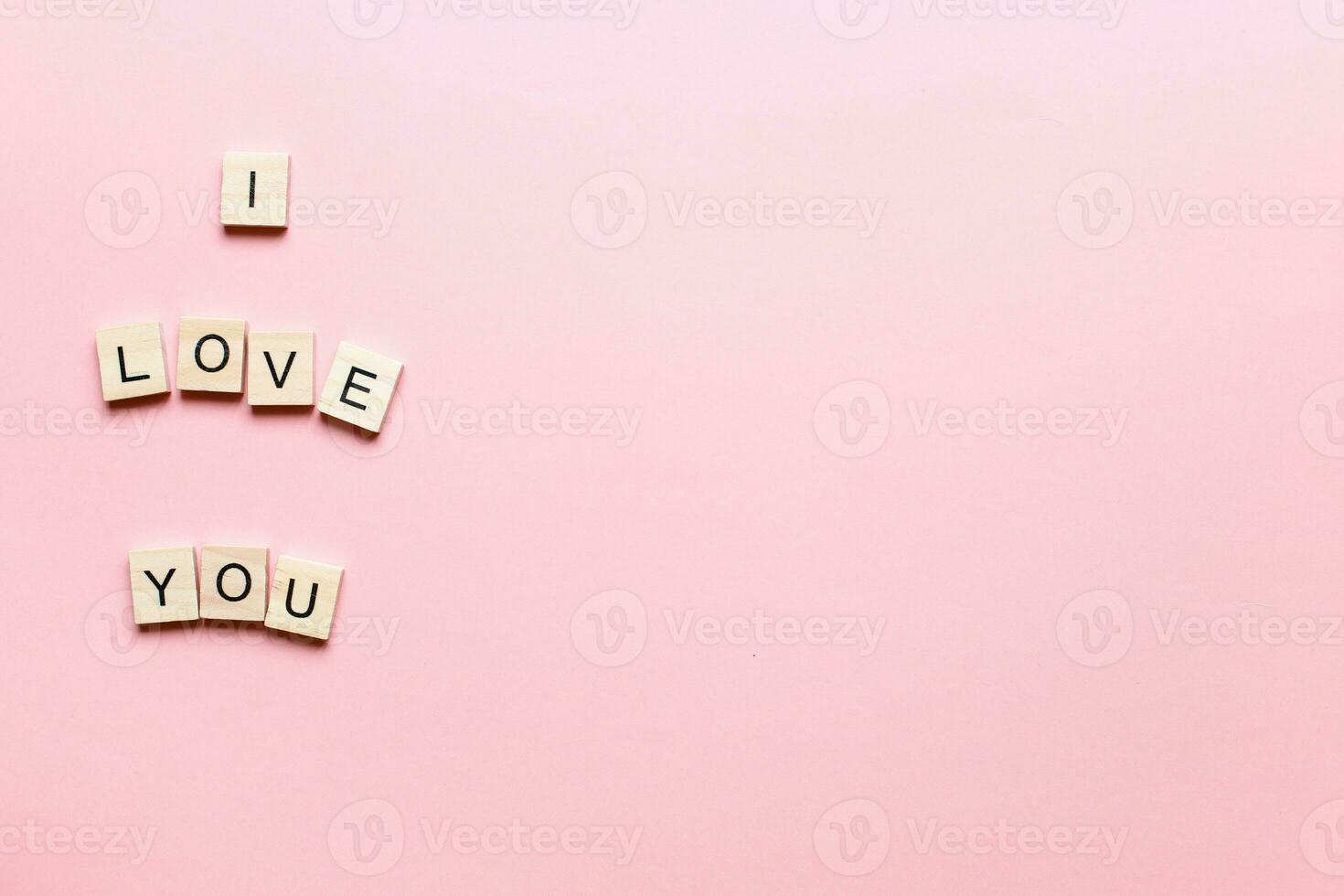 design jag kärlek du tillverkad av trä- brev på en rosa bakgrund. plant jag kärlek du. platt lägga valentines dag foto