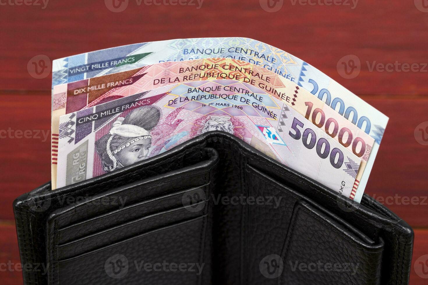guineanska franc i de svart plånbok foto