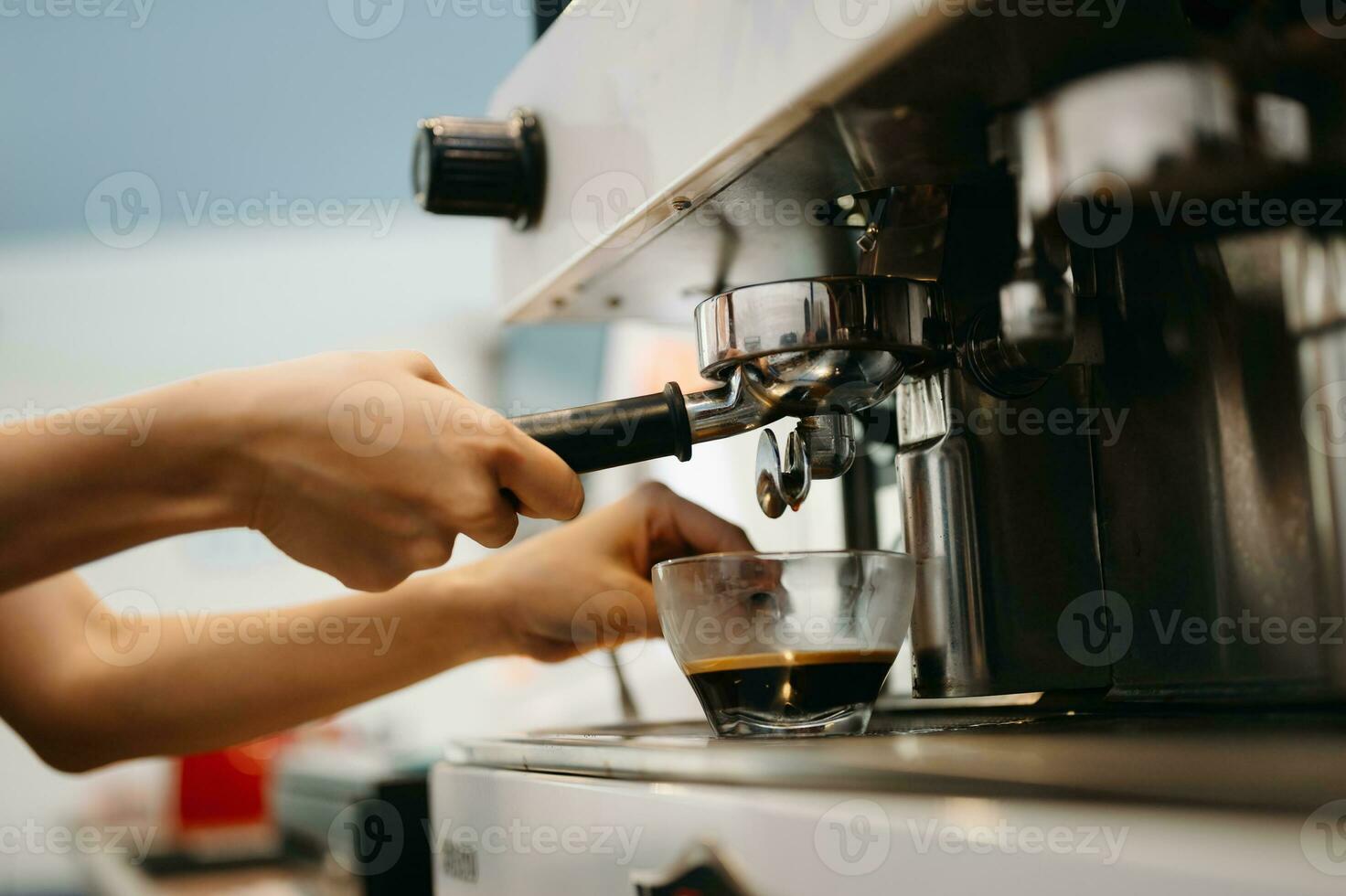 kopp och professionell espresso maskin häller färsk kaffe in i en glas kopp på Kafé foto