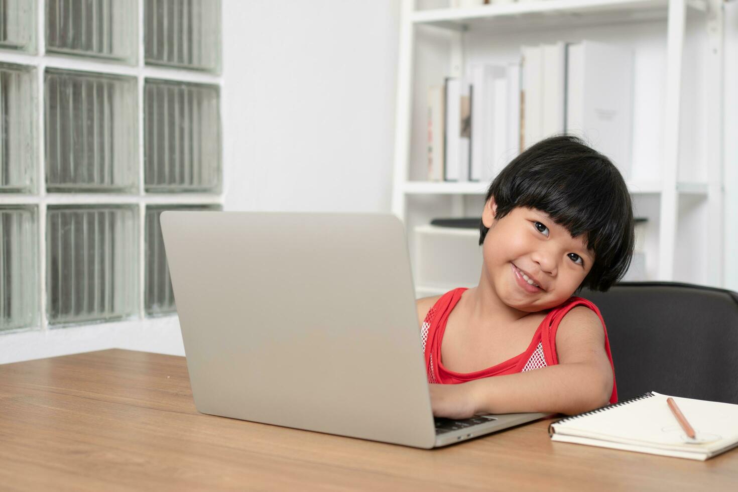Lycklig asiatisk flicka studerande uppkopplad inlärning klass från en dator med en lärare, uppkopplad utbildning är en teknologi för social distans i en ny vanligt livsstil, begrepp av Hem skola och handledare foto