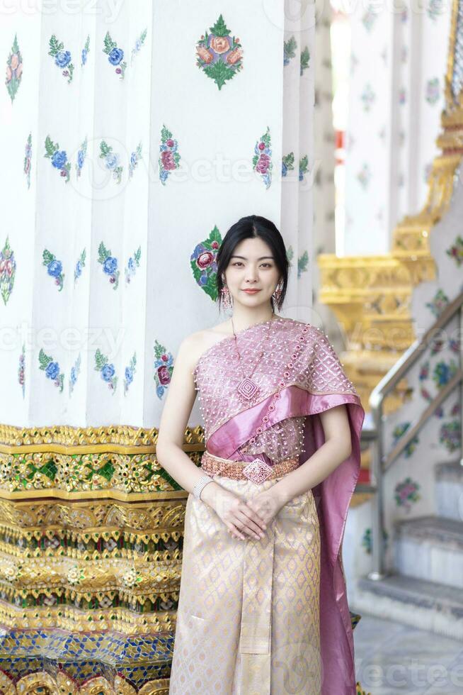 skön asiatisk flicka i thai traditionell kostym på tempel foto