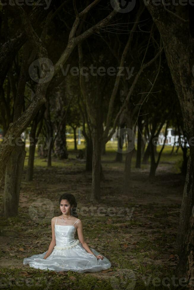 asiatisk flicka i bröllop klänning i de skog foto