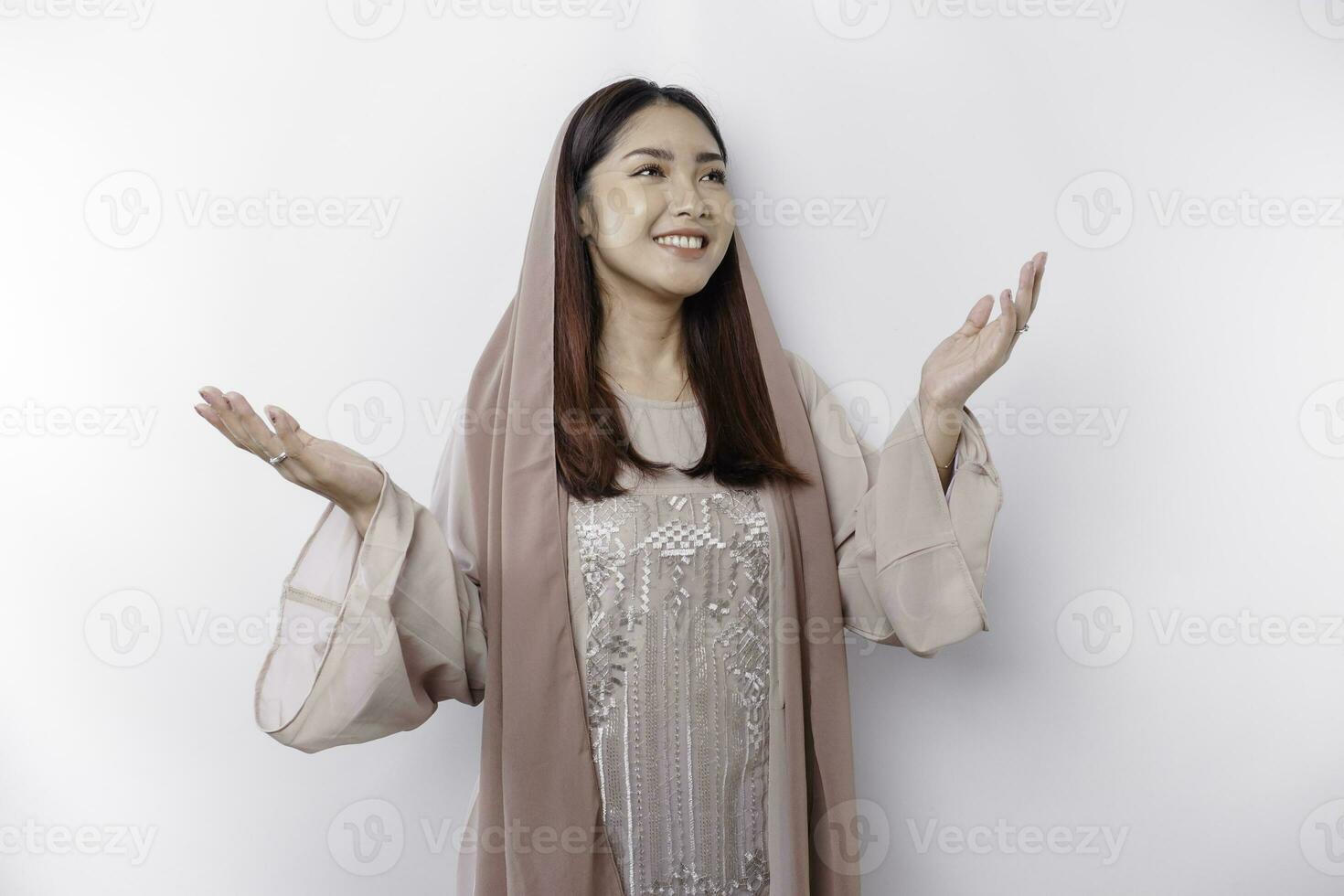 porträtt av en ung skön asiatisk muslim kvinna bär en slöja gestikulerar eid mubarak hälsning foto