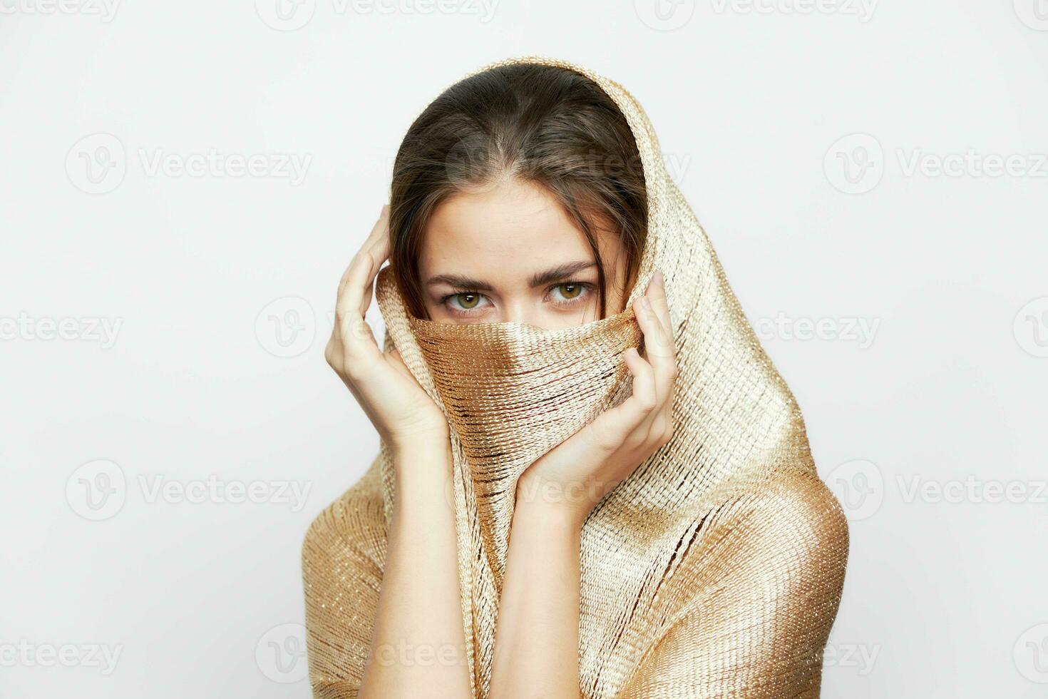 en flicka i en gyllene scarf omslag ansikte etnicitet religion smink foto