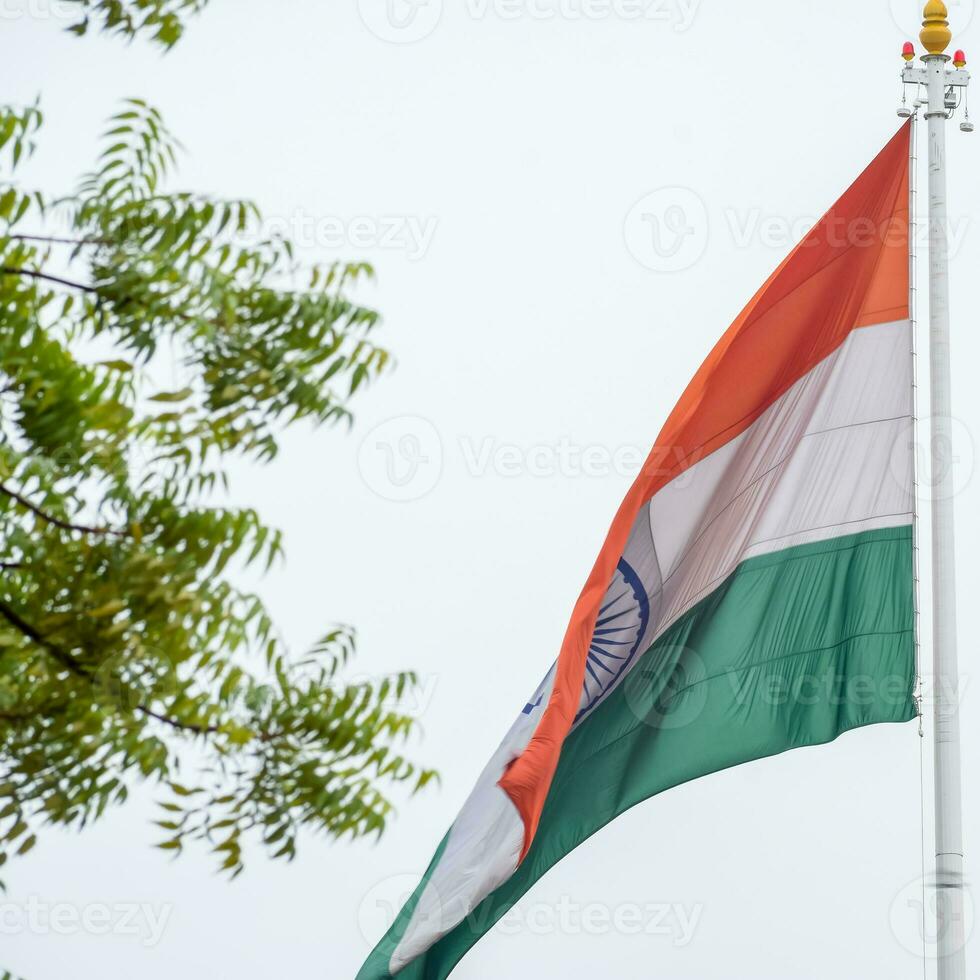 Indien flagga vajar högt på connaught plats med stolthet över blå himmel, Indien flagga vajar, indiska flaggan på självständighetsdagen och republikens dag i Indien, tilt up shot, viftande indiska flaggan, har ghar tiranga foto