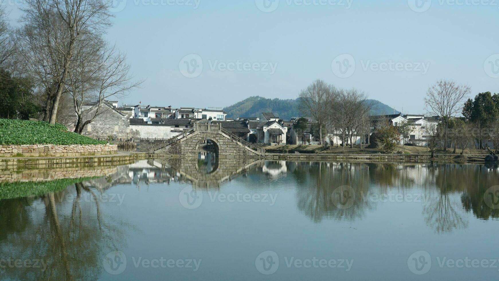 ett gammal traditionell kinesisk by se med de gammal välvd sten bro och gammal trä- byggnader i de sydlig landsbygden av de Kina foto