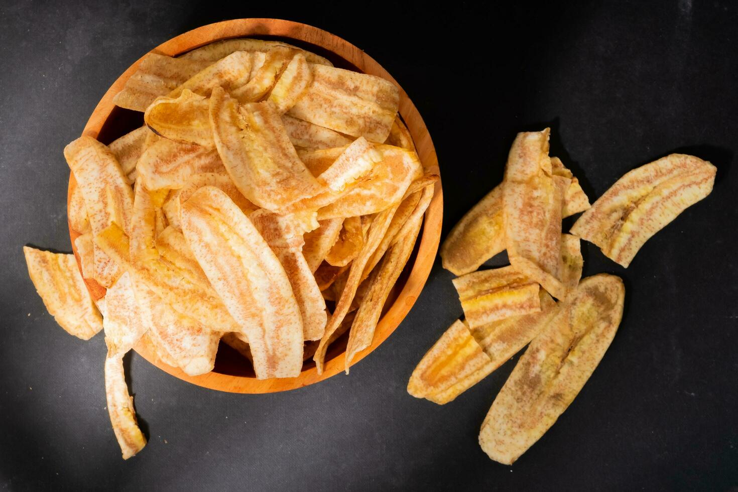 banan pommes frites med en ljuv och salt smak tillverkad från friterad rå bananer i en trä- skål. traditionell snacks foto