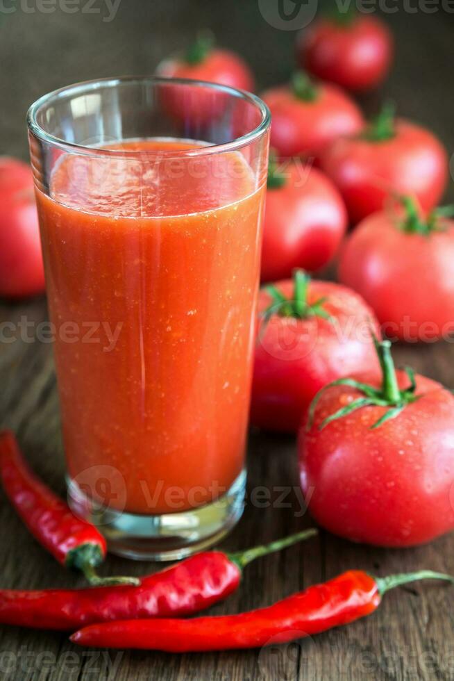 tomatsaft med färska tomater foto