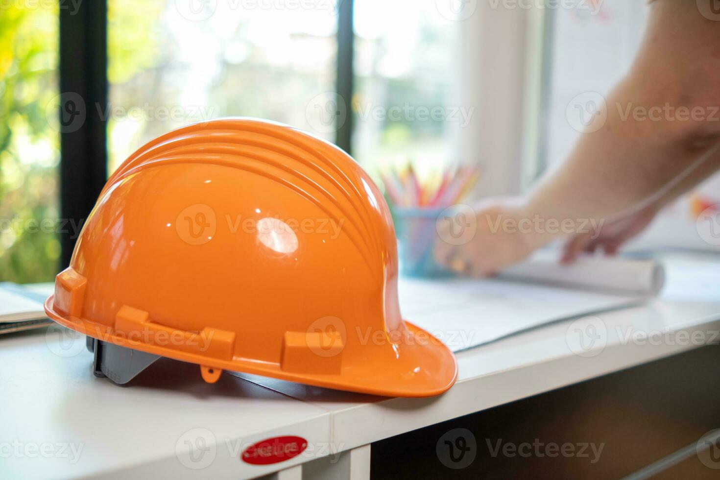 orange hård hattar sitta på konstruktion ingenjörer skrivbord eftersom hård hattar är grundläggande när som förs in i konstruktion webbplats för de säkerhet av ingenjörer. begrepp av bär hård hatt till skydda huvud i webbplats. foto