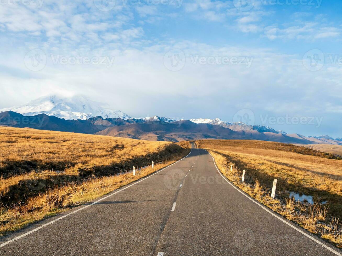 solig motorväg till de snötäckt toppar. höst morgon- folktom motorväg. skön asfalt motorväg, motorväg, motorväg genom av caucasian landskap bergen kullar. foto
