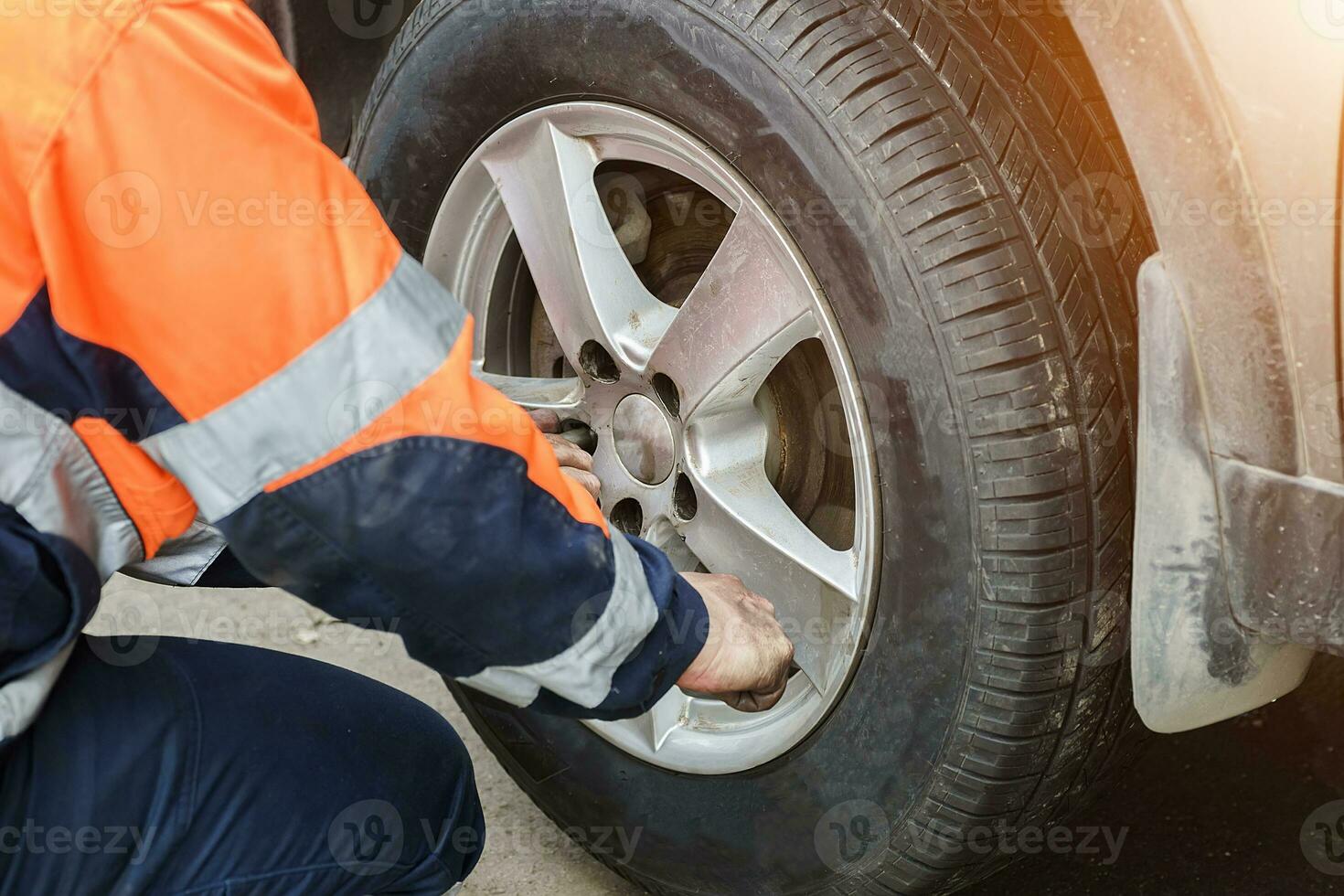 bil hjul ersättning. självbetjäning däck passande begrepp. använder sig av en hjul rycka till vrida de hjul nötter.. foto