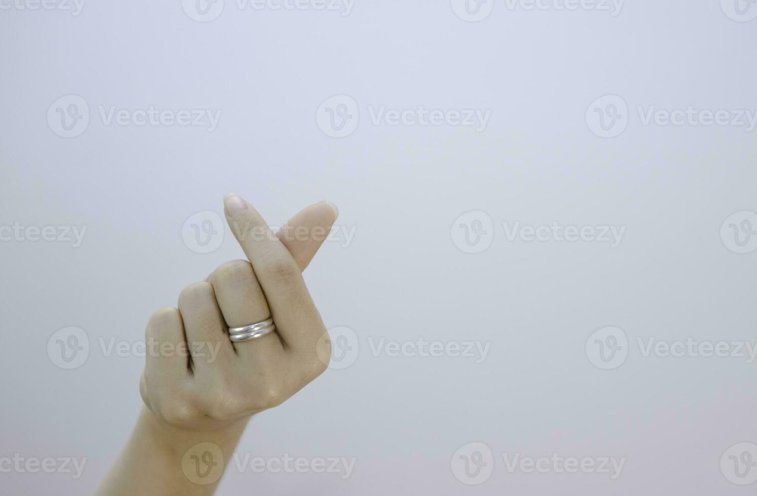 kvinna hand som visar små hjärta på en vit isolerat bakgrund, närbild mini hjärta tecken förbi kvinnor hand foto