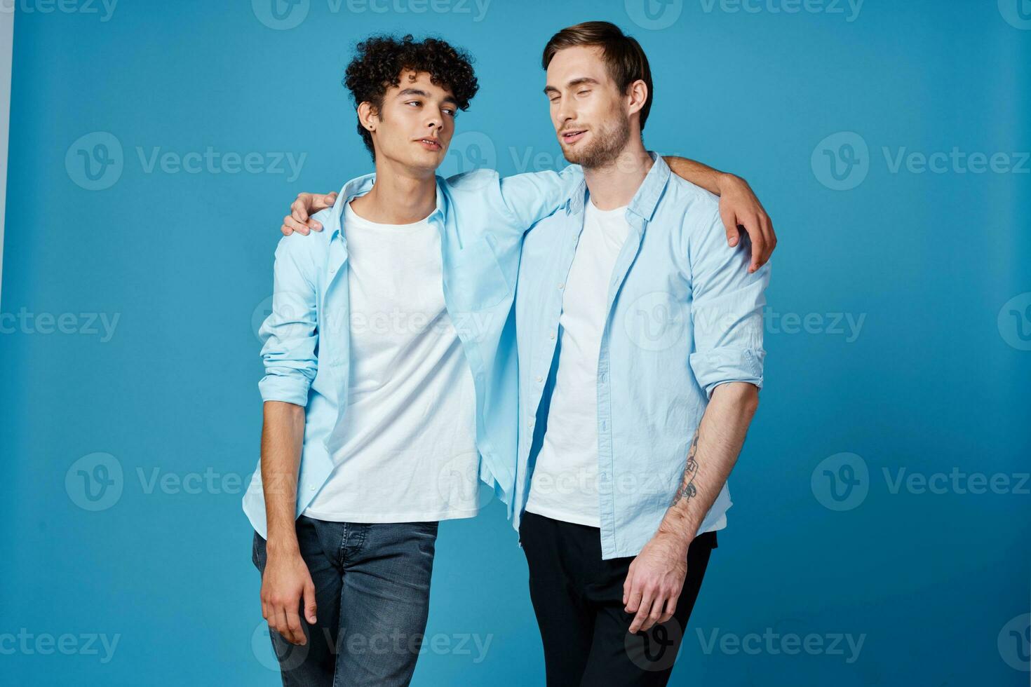 bäst vänner kramas på blå bakgrund i matchande t-tröjor beskurna se foto