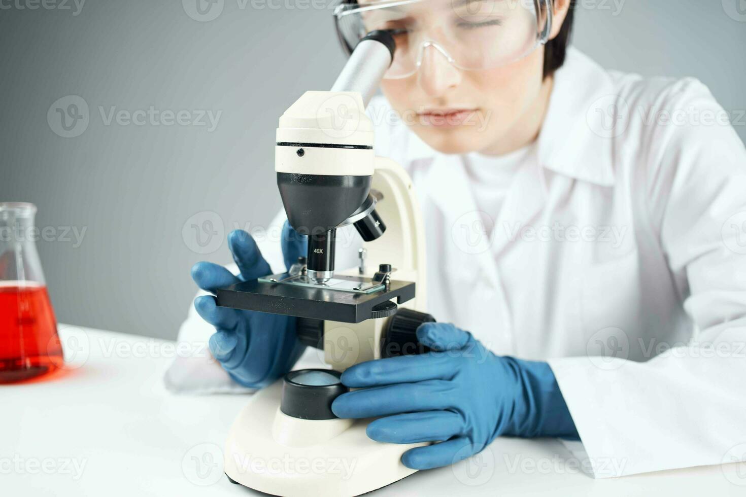 laboratorium assistent ser genom en mikroskop vetenskap forskning teknologi experimentera foto