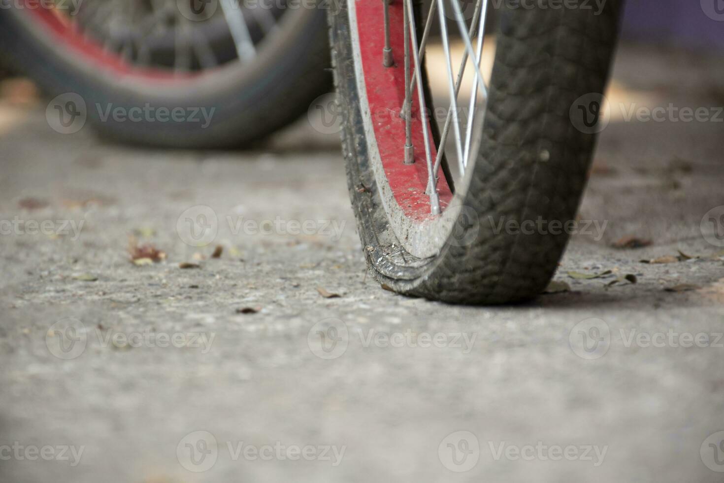 ett gammal cykel som har platt däck och parkerad förbi de urban väg och väntade till fixera eller till förändra de ny ett och till påfyllning de luft inuti, mjuk fokus. foto