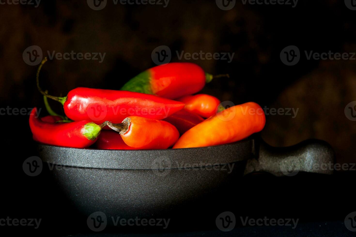 röd varm chili paprikor på svart bakgrund foto