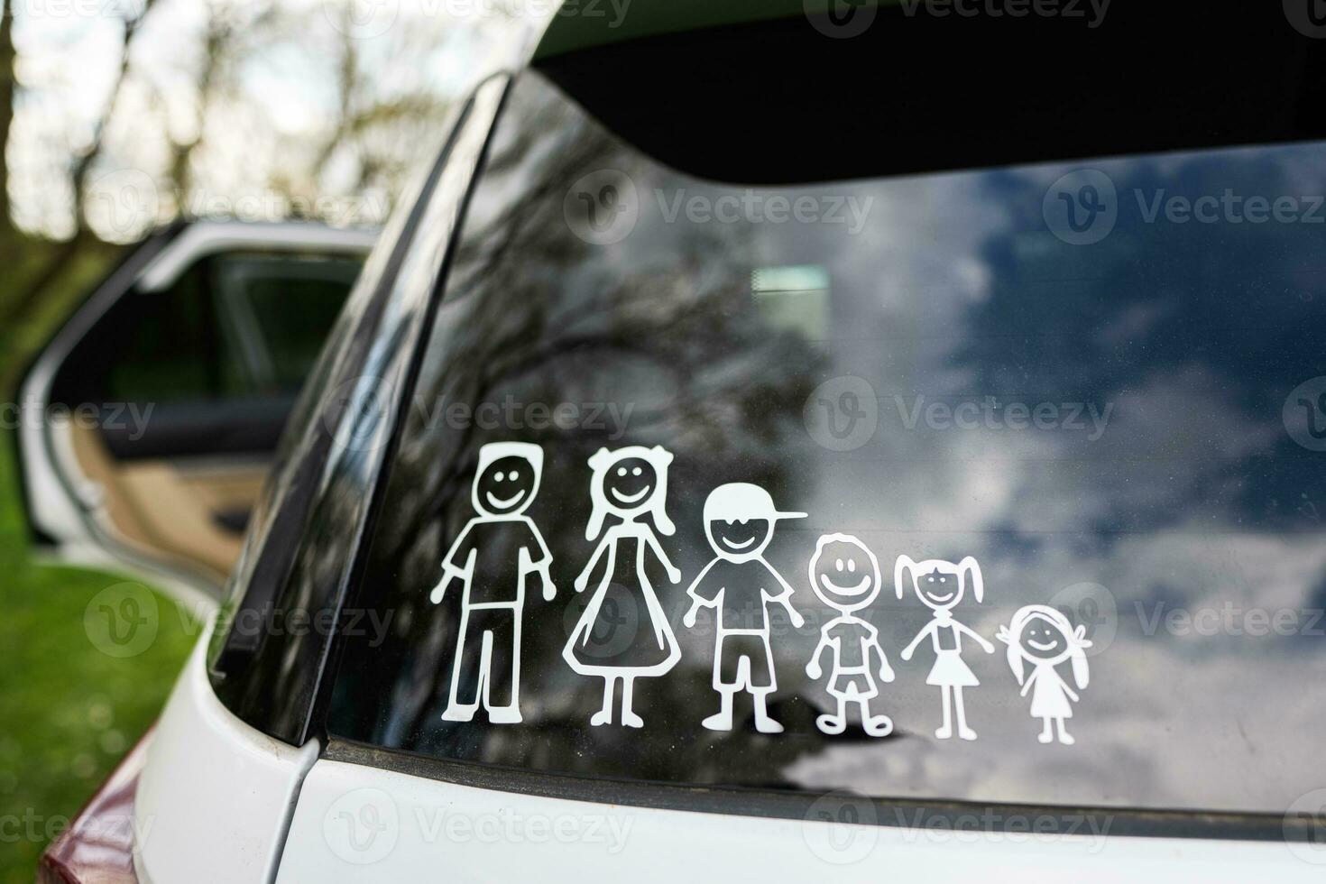 Lycklig familj på styrelse. klistermärke på de tillbaka av bil. fyra ungar. foto