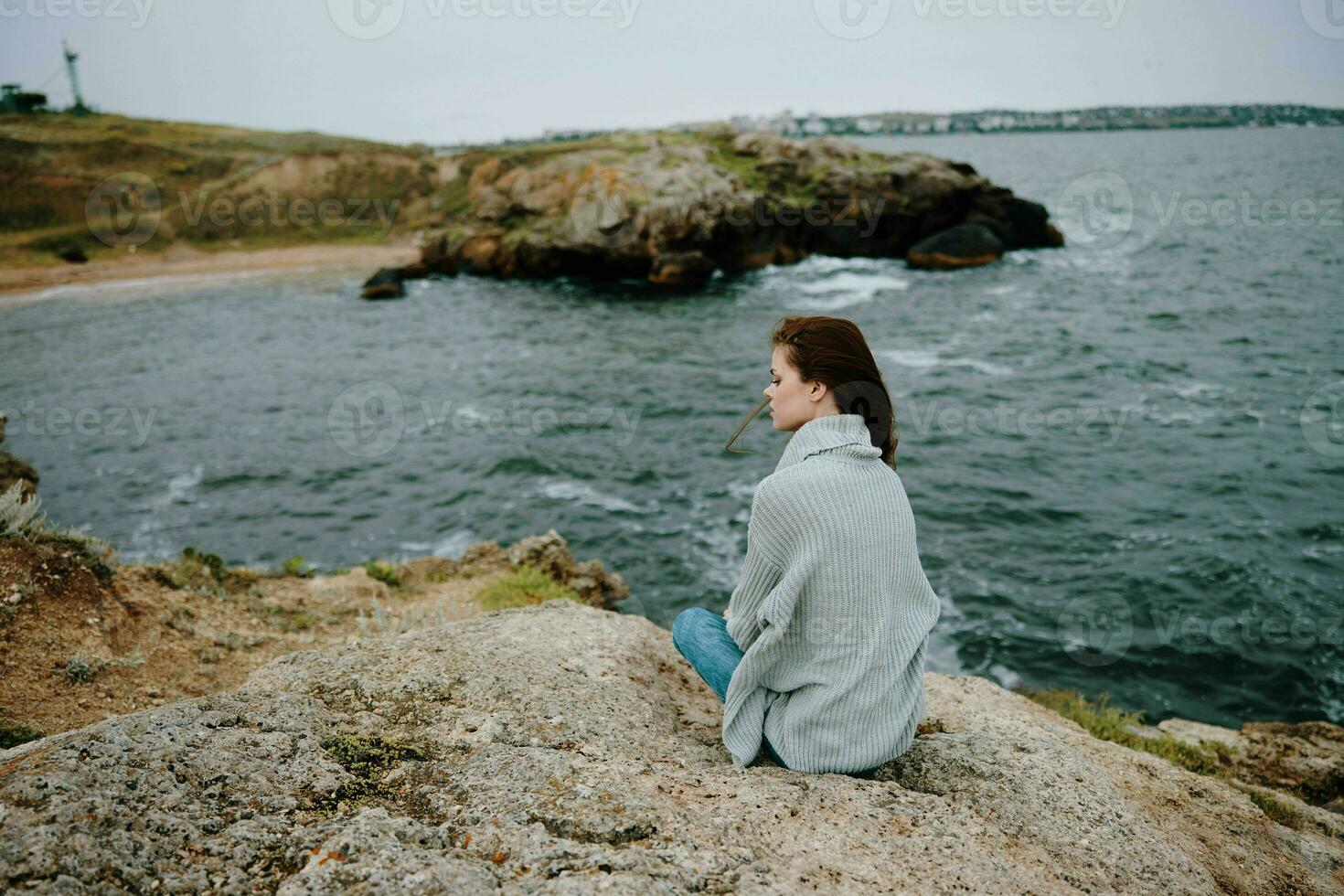 Söt kvinna tröjor molnig hav beundrande natur oförändrad foto