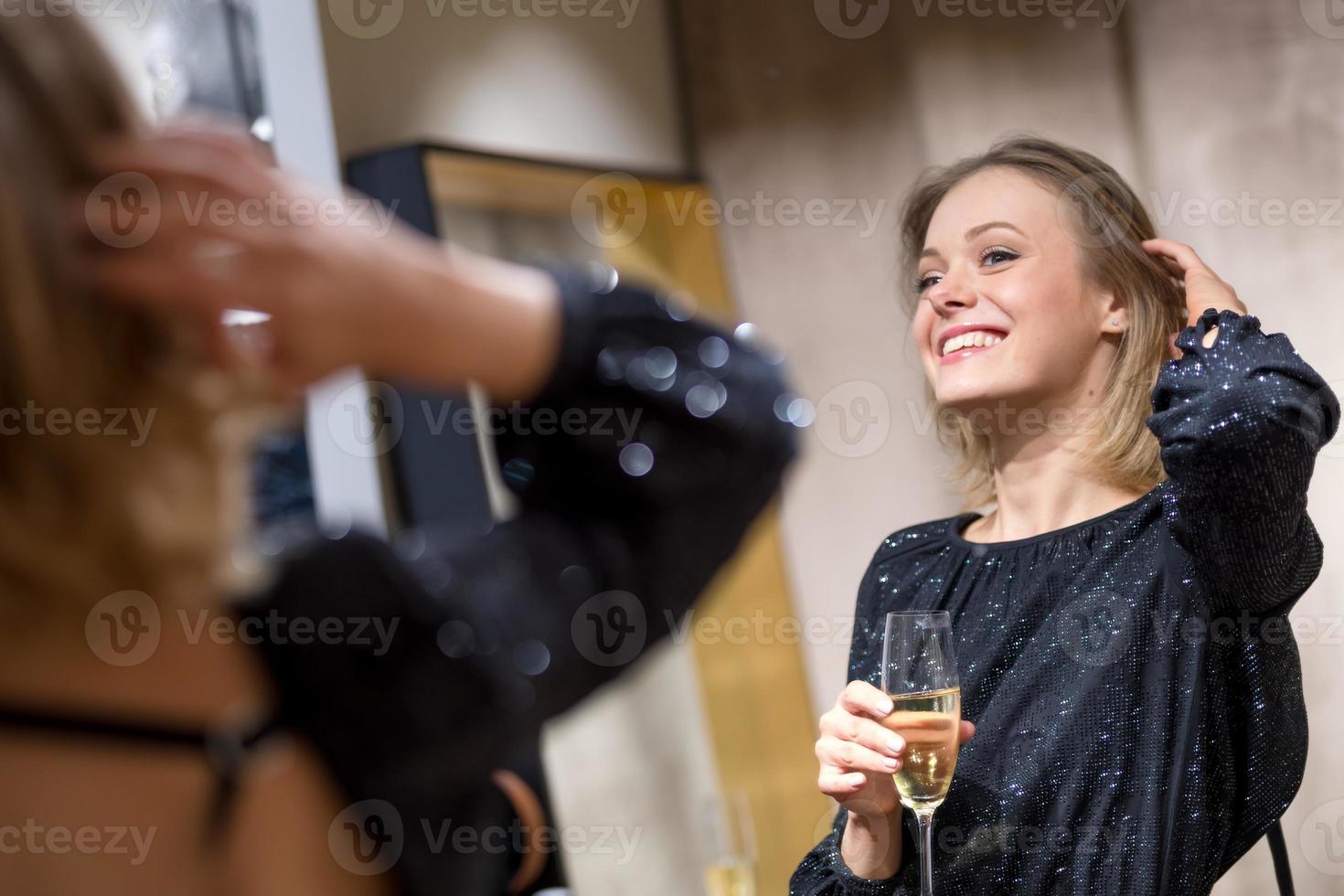 attraktiv ung kvinna som dricker vid spegeln foto
