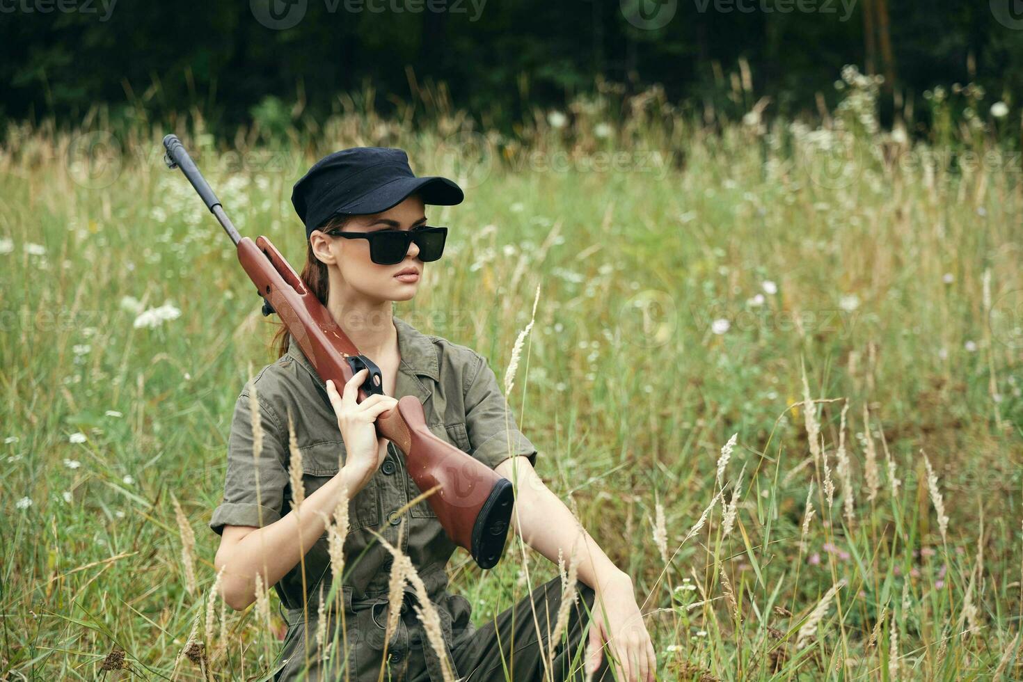 kvinna på natur solglasögon med vapen på de axel skyddande i de gräs vapen foto