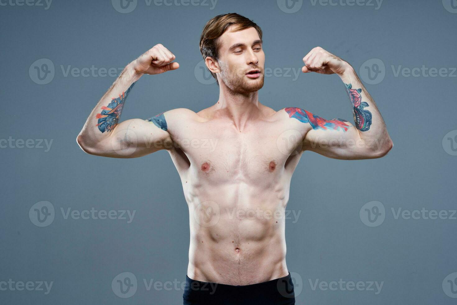 stark manlig idrottare med pumpade upp ärm muskler och tatuering kroppsbyggare kondition foto