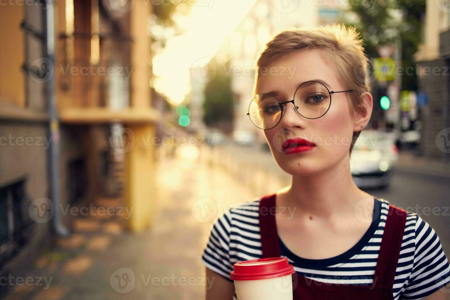 kvinna med kort hår utomhus bär glasögon gående i sommar foto