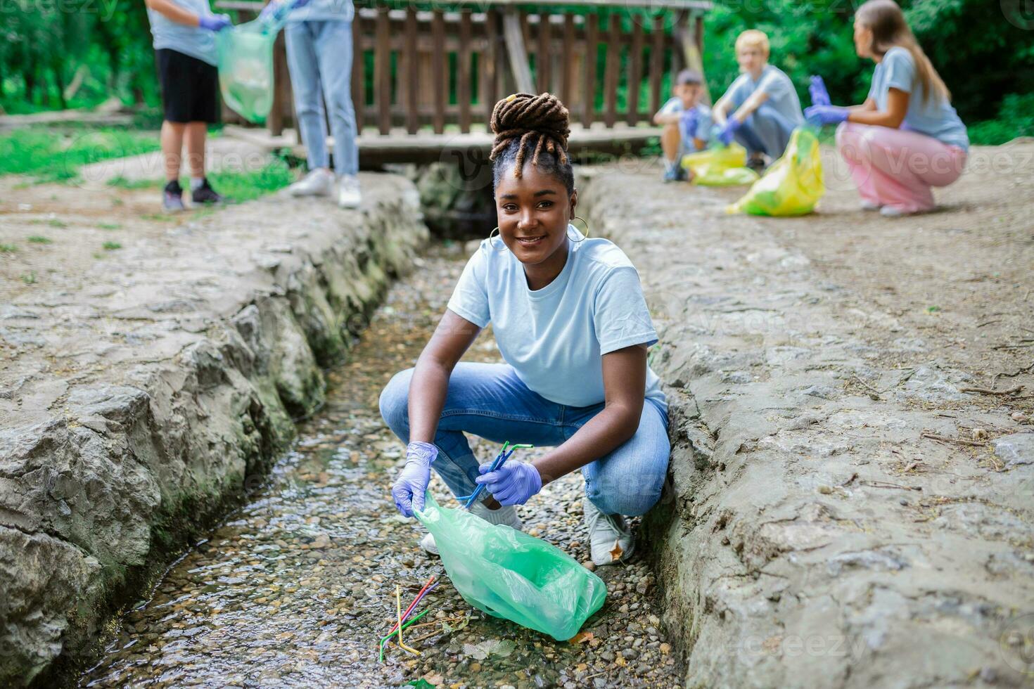 kvinna handplockning sammankomst upp sopor plast strån sopor från de flod på de parkera. värld miljö dag.miljö begrepp. foto