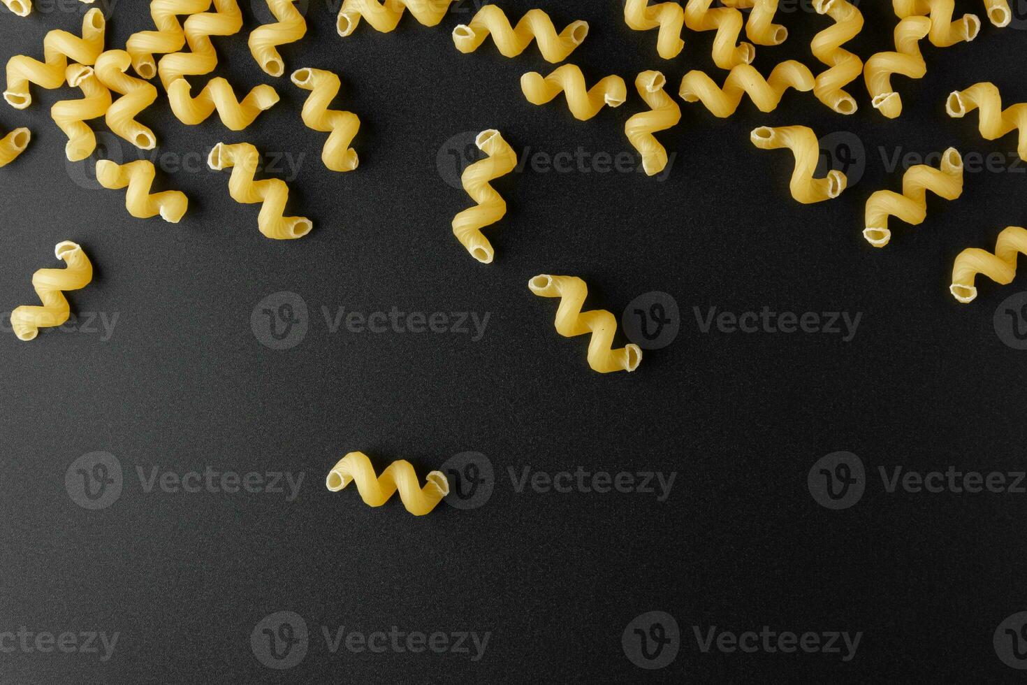 rå pasta cavatappi med kopia Plats på svart bakgrund. foto