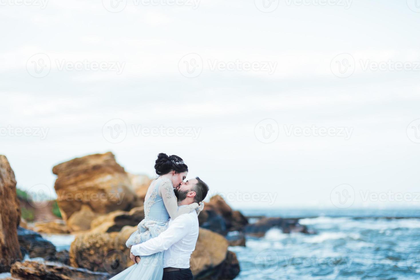 samma par med en brud i en blå klänning promenad foto