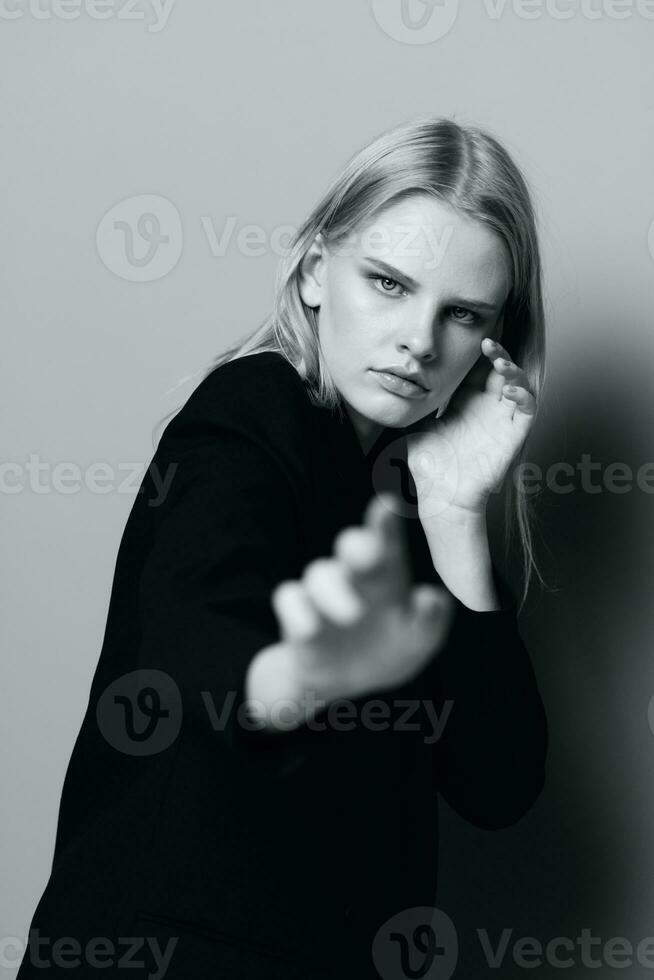 en ung otrolig blond drar henne händer in i de kamera Framställ i de studio. konst mode fotografi foto