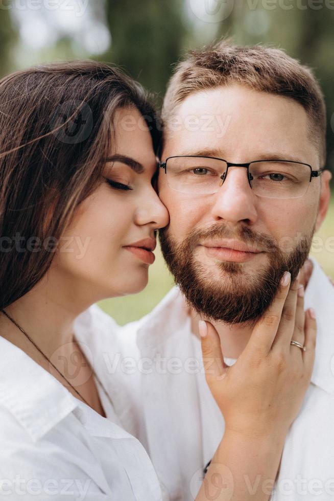 ungt par i kärlek en kille med skägg och en tjej med mörkt hår i ljusa kläder foto