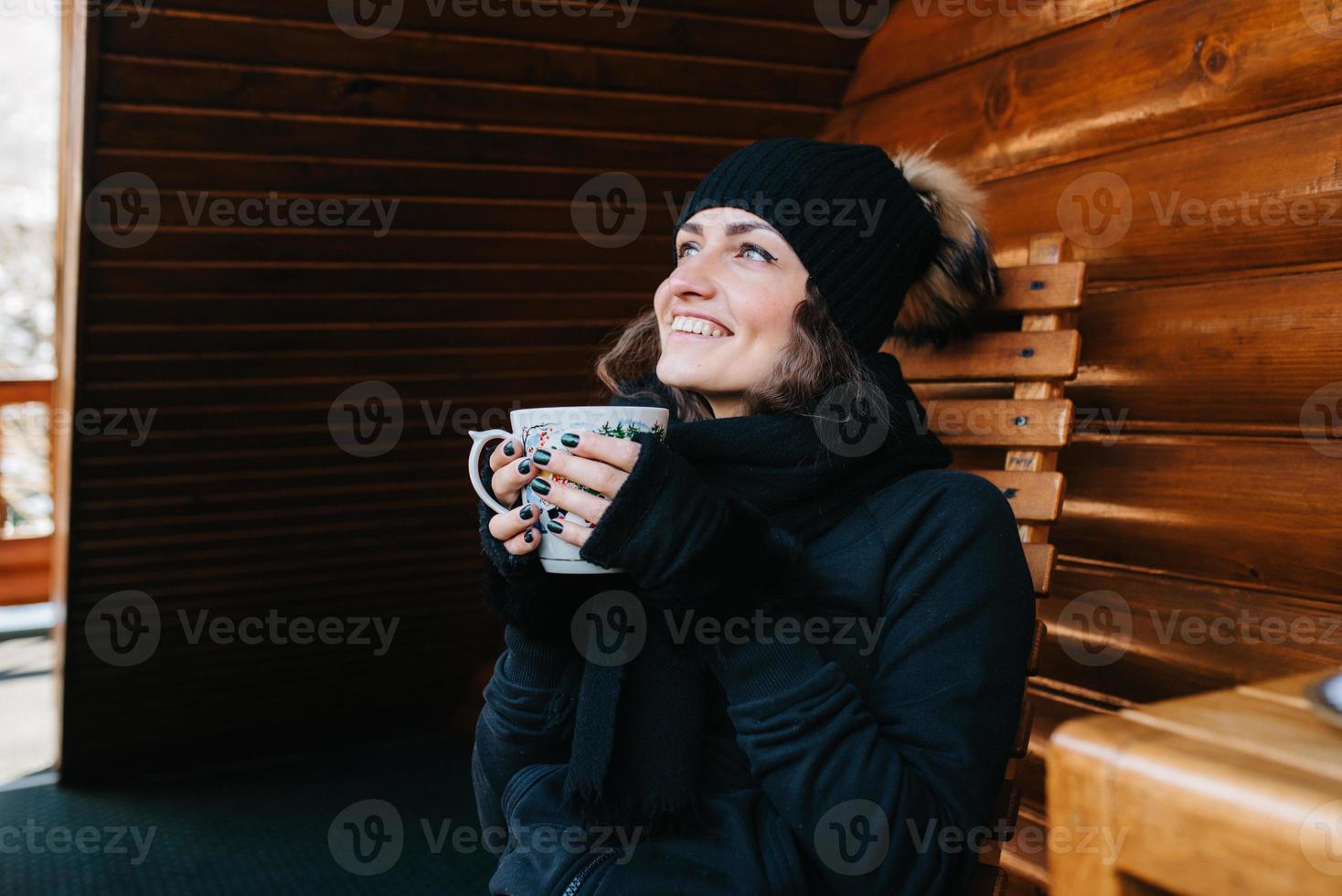 flicka på verandan av ett snötäckt trähus foto