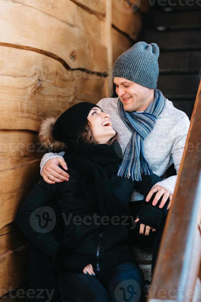 par ungdomar en kille och en tjej på verandan i ett snötäckt trähus foto