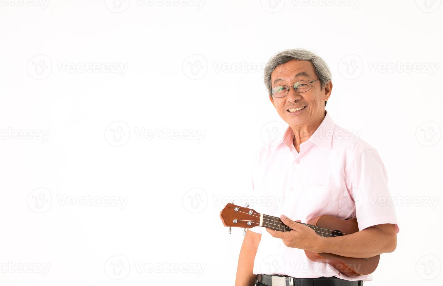 senior asiatisk man med ukulele, isolerad foto