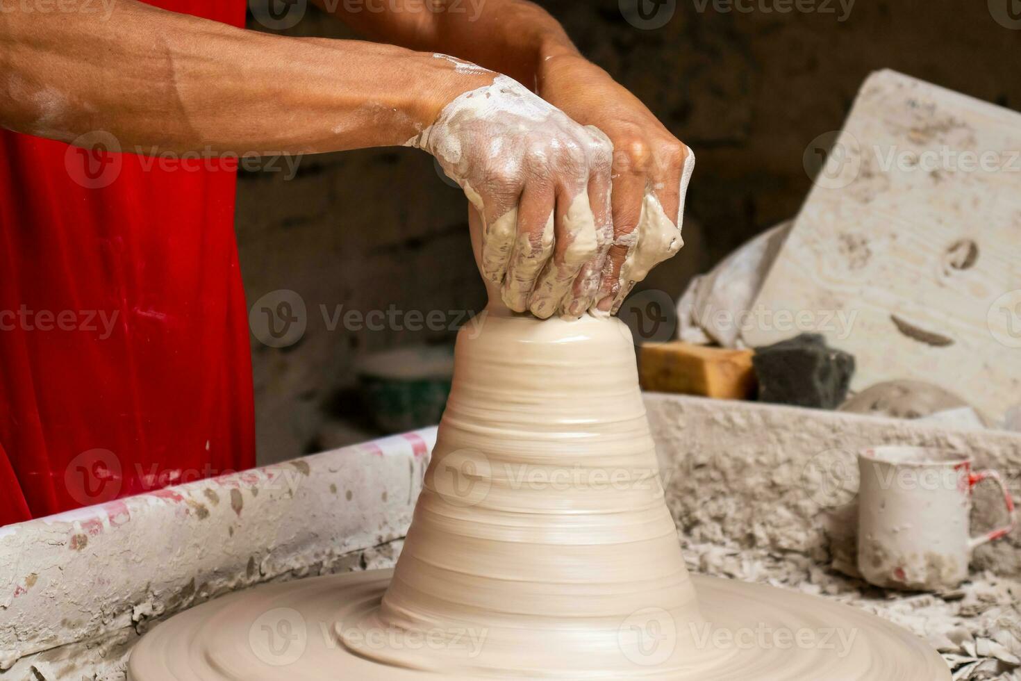 man framställning keramisk artiklar på de krukmakare hjul i en traditionell fabrik i de stad av raquira belägen i de avdelning av cundinamarca i colombia foto