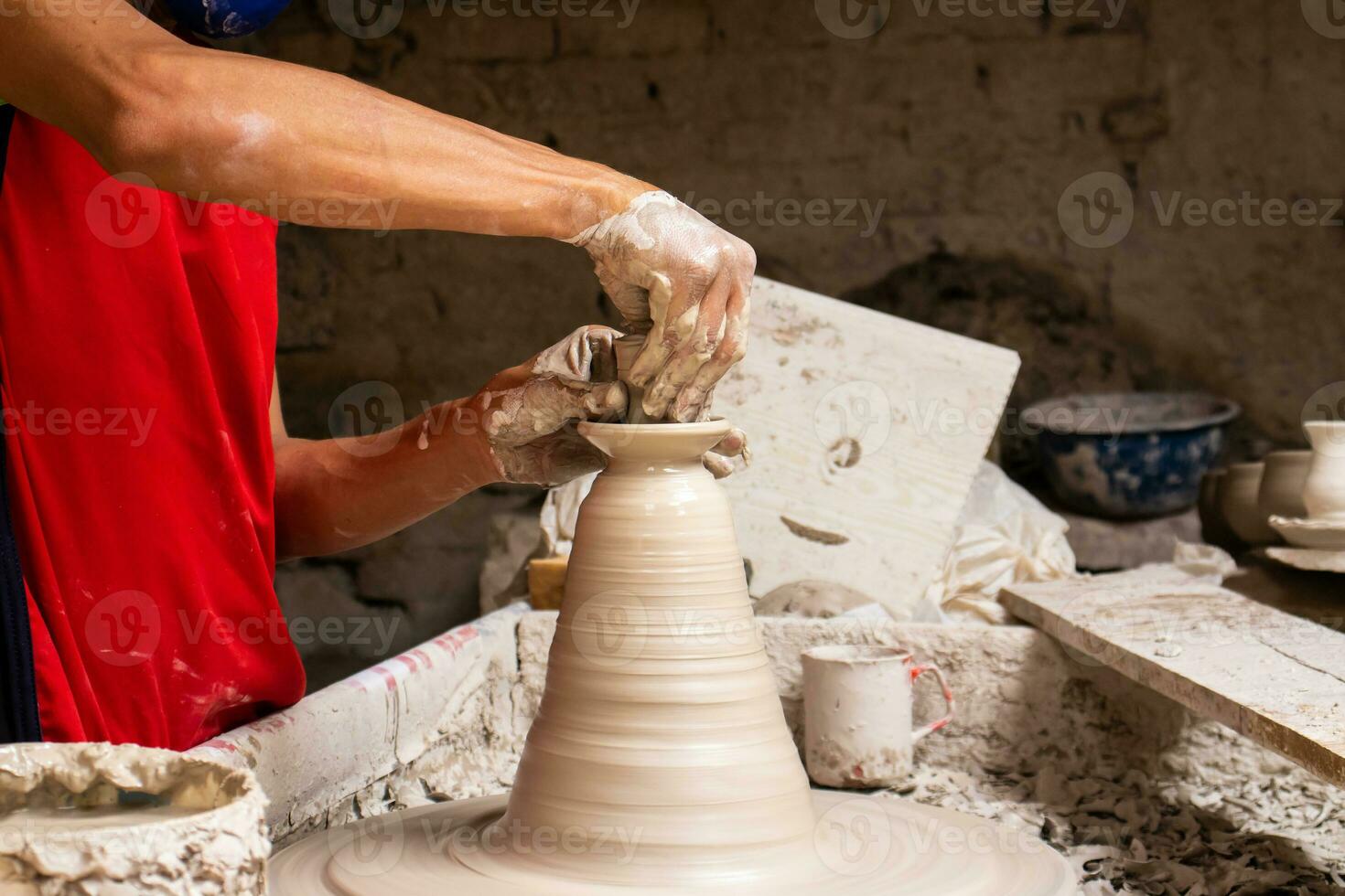 man framställning keramisk artiklar på de krukmakare hjul i en traditionell fabrik i de stad av raquira belägen i de avdelning av cundinamarca i colombia foto