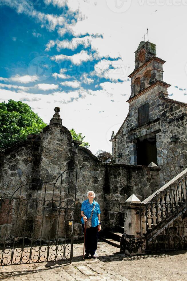 senior kvinna på de skön historisk kyrka la ermita byggd i de sextonde århundrade i de stad av mariquita i colombia foto