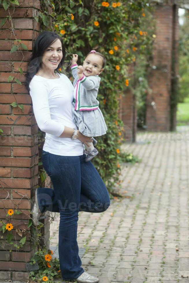 mamma och bebis flicka på de trädgård foto